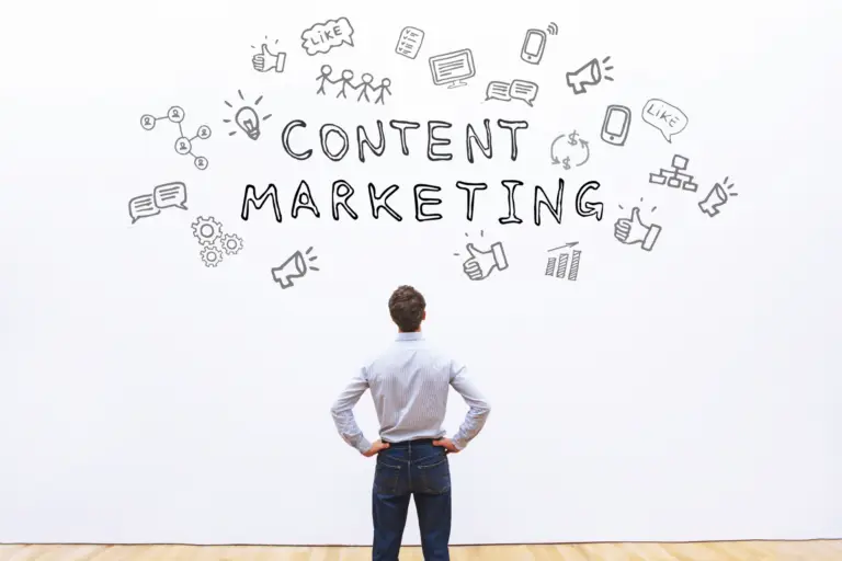 A man, seen from the rear, looks up at thw ords "content marketing" written on a wall